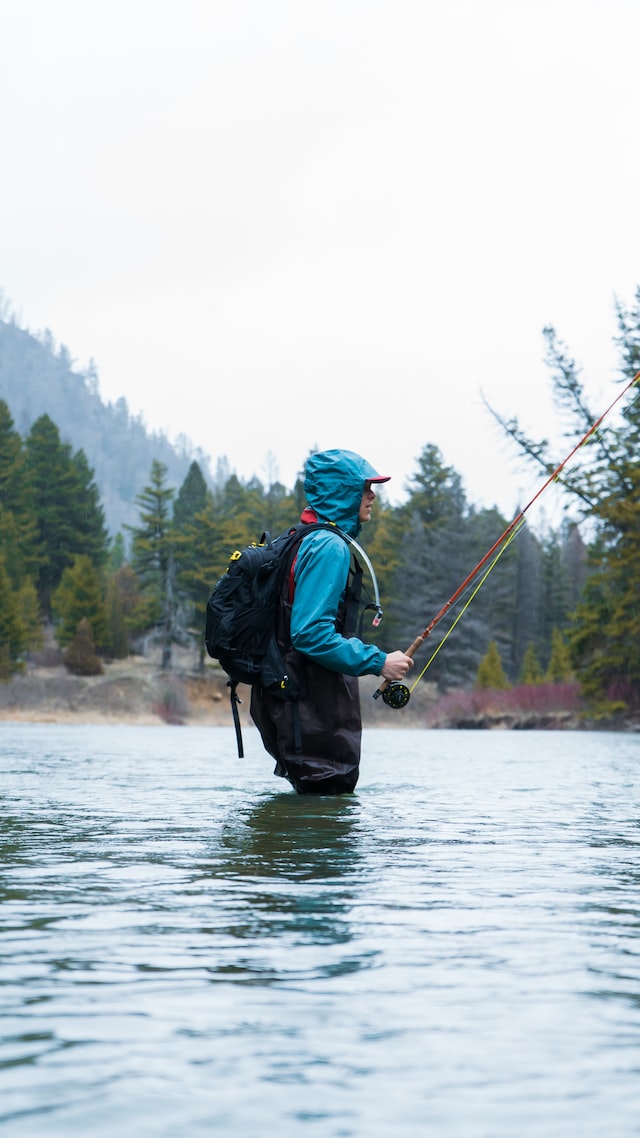 Girl in water with a fishing rod